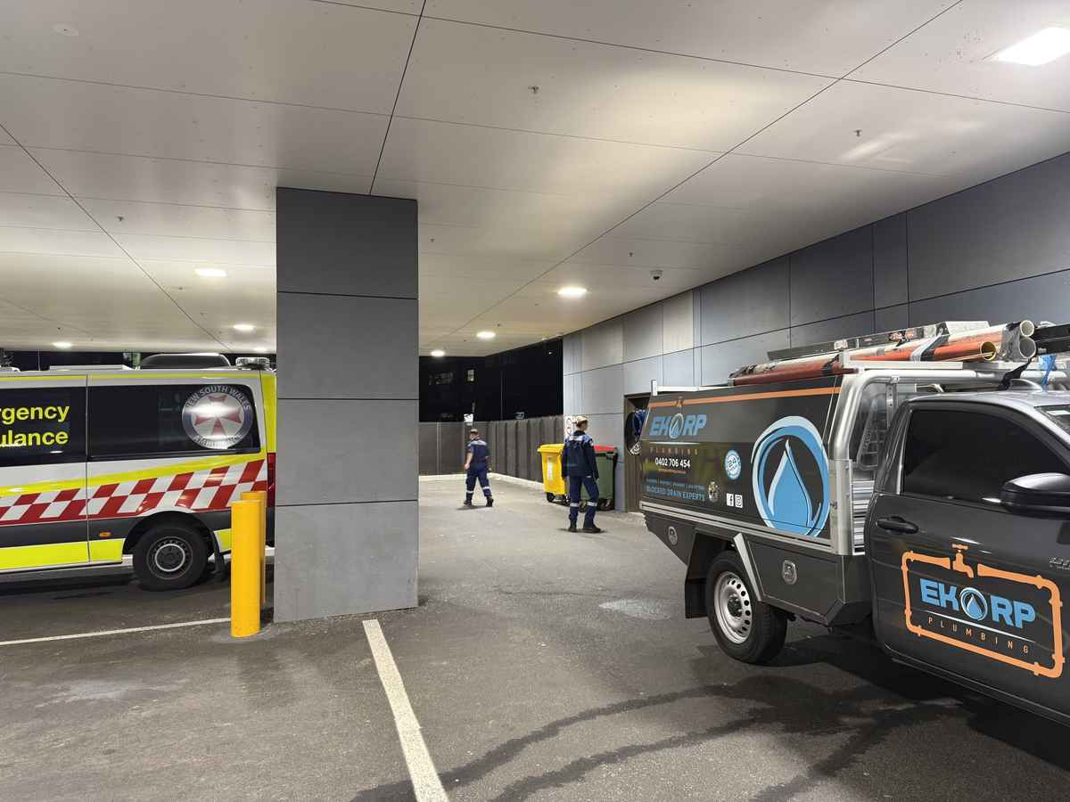 A plumbing service vehicle outside a hospital emergency entrance
