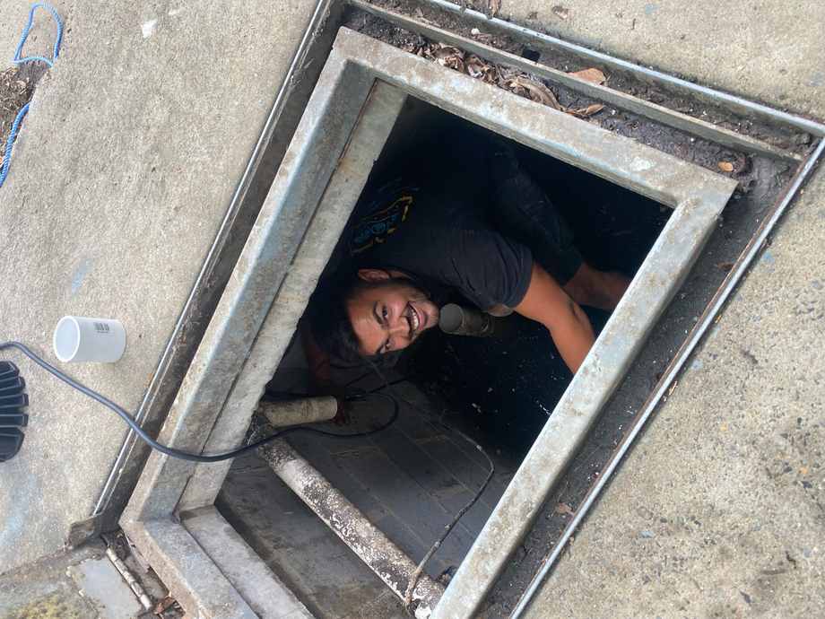 A plumber inspecting underground pipework